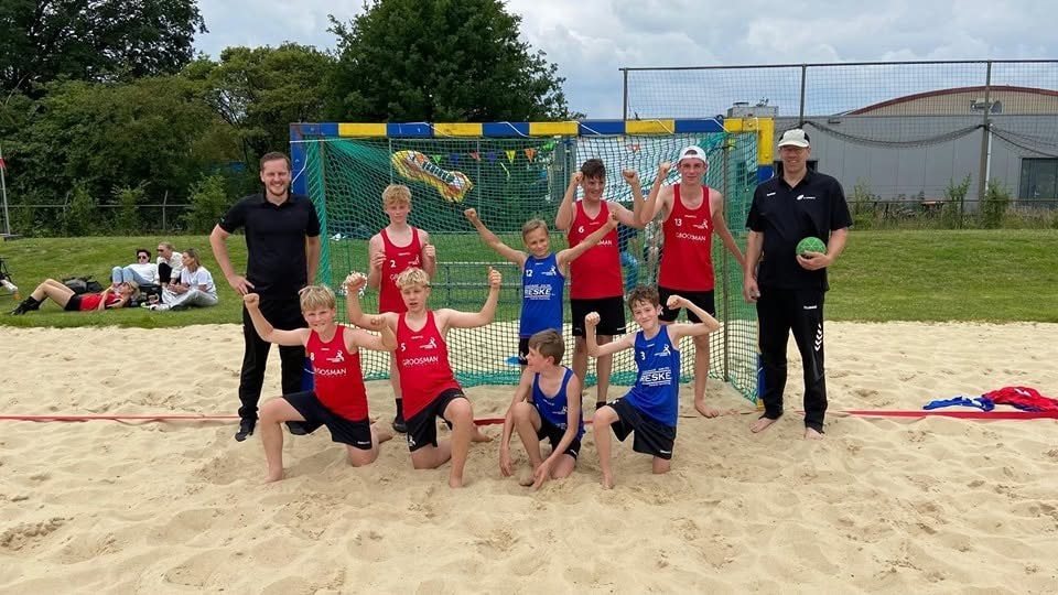 Beachhandbalteam poseert voor het doel